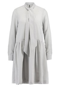 Randig klänning i ljusgrå, med ståkrage, långa ärmar och knytning vid halsringningen. Kjol med utsvängd och insydda veck.