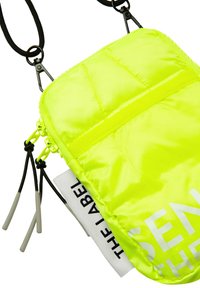 Neon yellow crossbody bag made of padded nylon, featuring a front pocket, drawstring accents, and a white printed logo.