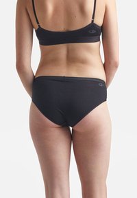 Čierna bavlnená športová podprsenka a nohavičky, so hladkou textúrou a minimalistickým dizajnom so zvýraznením loga na páske.