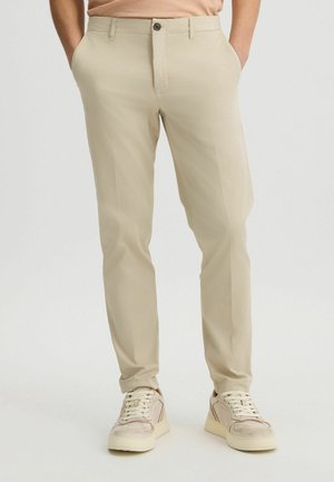 Beige, slim-fit chinos gemaakt van lichtgewicht stof, met een gladde textuur, voorzakken en een knoopsluiting. Geschikt voor casual kleding.
