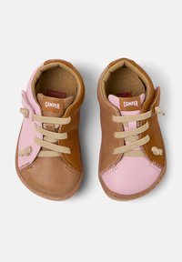 Scarpe in pelle marrone e rosa con punte arrotondate, superfici texturizzate, lacci beige e brand Camper sul tallone e sulla linguetta.
