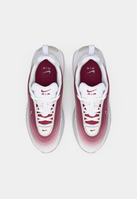 Tenisky Nike Air Max 97 s prechodom z vínovej do bielej farby na vrchu, biele šnúrky a textúrovaná podrážka, s brandovaním 'AIR' na jazyku.
