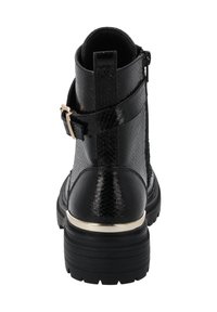 Botín negro con un estampado de serpiente sintético texturizado, herrajes dorados, una correa con hebilla y una suela de goma gruesa para mayor agarre.
