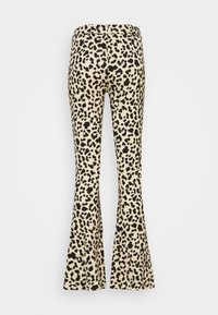 Leopard print flared pants featuring a beige base with black spots. Smooth fabric with a fitted waist and flare starting at the knee.