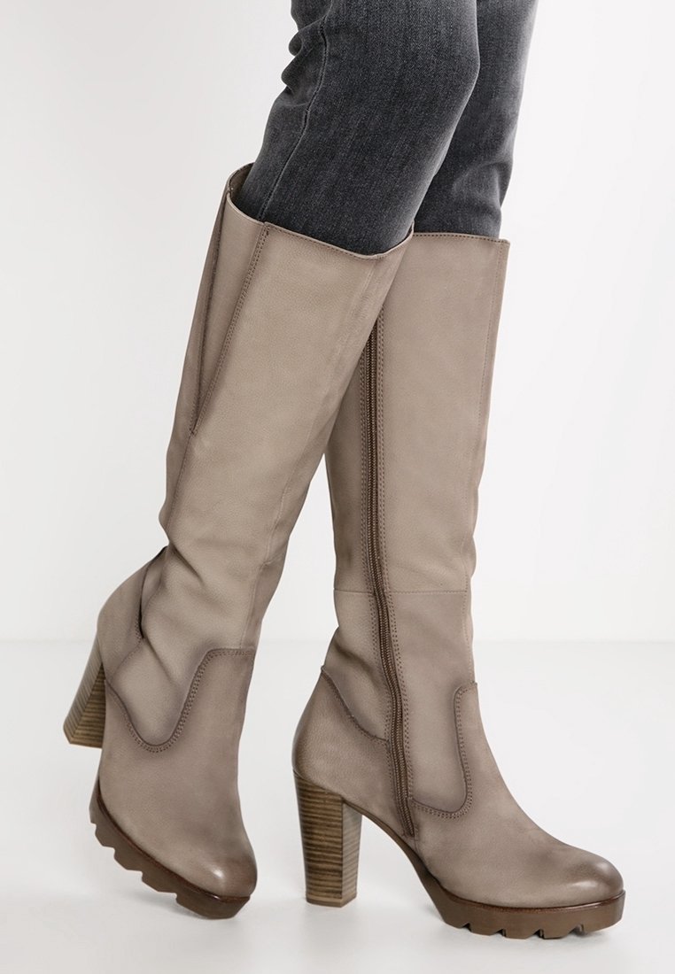 Bottes beige montant jusqu'au genou en cuir, avec une finition texturée, un talon en bois épais et une fermeture éclair latérale.