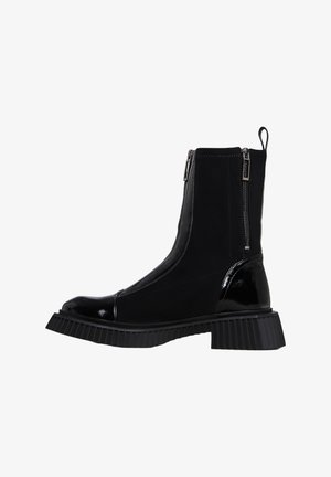Stivaletti neri alla caviglia con texture lucide e opache, dotati di doppi cerniere laterali, suola spessa a coste e design con punta rotonda.