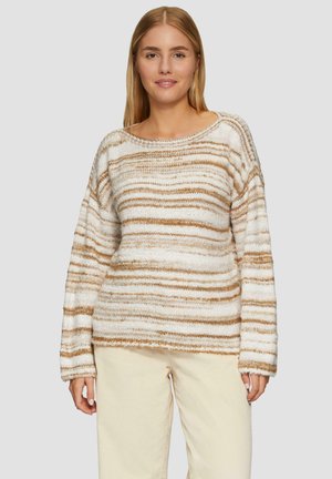 Pull en tricot à rayures crème et beige, doté d'une coupe décontractée, d'un large col et de manches longues, associé à un pantalon en velours côtelé de couleur claire.