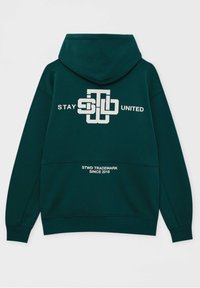 Sudadera con capucha verde que presenta un logotipo gráfico en blanco con el texto "STAY UNITED" y "STWD TRADEMARK SINCE 2018" en el dobladillo. Material de mezcla de algodón.