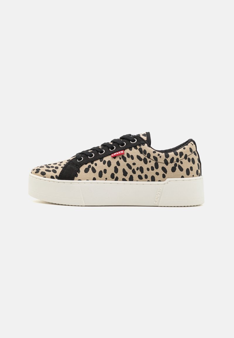 Beige plátěné tenisky s černými leopardími skvrnami, černými semišovými detaily a bílou gumovou podrážkou. Obsahují černé tkaničky a malou červenou štítkovou značku.