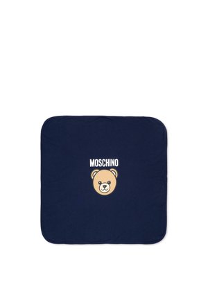 Granatowy kwadratowy kawałek tkaniny z zaokrąglonymi narożnikami, na którym znajduje się twarz misia w centrum oraz tekst "MOSCHINO" nad nią.