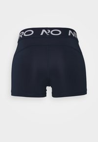 Marineblaue Boxershorts mit einem schwarzen Bündchen, das weißen Text aufweist. Glatte Textur und figurbetontes Design, geeignet für Sportbekleidung.