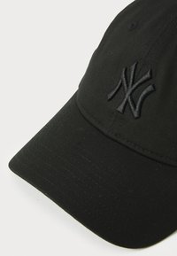 Cappellino da baseball nero realizzato in tessuto, con logo NY ricamato. Il design include una visiera curva e una texture con cuciture visibili.