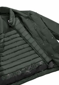 Giacca verde scuro con fodera interna trapuntata, tasche con zip e una superficie esterna liscia. Leggera e dal design moderno.