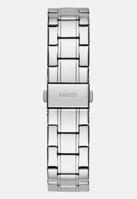 Srebrna bransoleta zegarka ze stali nierdzewnej z prostokątnym wzorem ogniw, o wypolerowanym wykończeniu, z centralnym zapięciem z logo "GUESS".