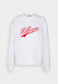 Sudadera blanca con cuello redondo, mangas largas y logotipo "Hilfiger" en rojo. Fabricada en material suave, presenta un ajuste relajado y puños de canalé.