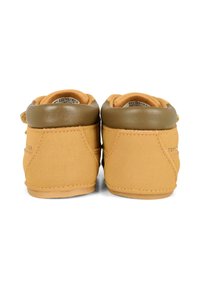 Tan neplederen schoenen met een bruine gevoerde kraag, gestikte accenten en een ronde vorm. Heeft een logodetail nabij de hak.