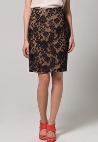 Pitkähihainen pitsihame, jossa on musta-beige kukkakuvio. Valmistettu teksturoidusta materiaalista, tiukasti istuva ja polven pituinen muotoilu.