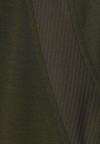 Olivgrüner Stoff mit glatter Textur, der diagonale Rippenakzente und flache, kontrastierende Nähte aufweist. Geeignet für Sportbekleidung.