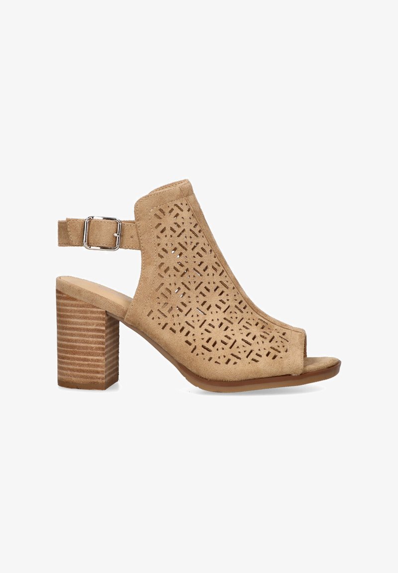 Sandalias de tacón bloque en ante beige con recortes geométricos, punta abierta, correa al tobillo con hebilla de metal y un tacón de madera texturizada.