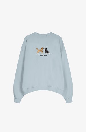 Felpa azzurra chiara con design cropped. Presenta due cani illustrati e la scritta 'I cani sono le mie persone preferite' in nero.