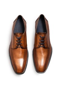 Paar polierte braune Herrengeschäftsschuhe aus Leder mit schwarzen Schnürsenkeln, sichtbaren Nähten und spitzen quadratischen Zehen auf weißem Hintergrund.