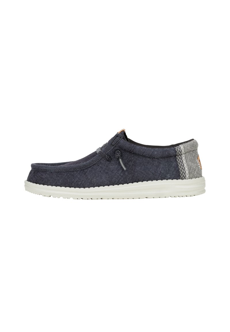 Scarpe slip-on con tomaia in tessuto blu scuro, retro grigio chiaro, suola in gomma bianca e cuciture decorative. Punta rotonda e senza chiusure visibili.