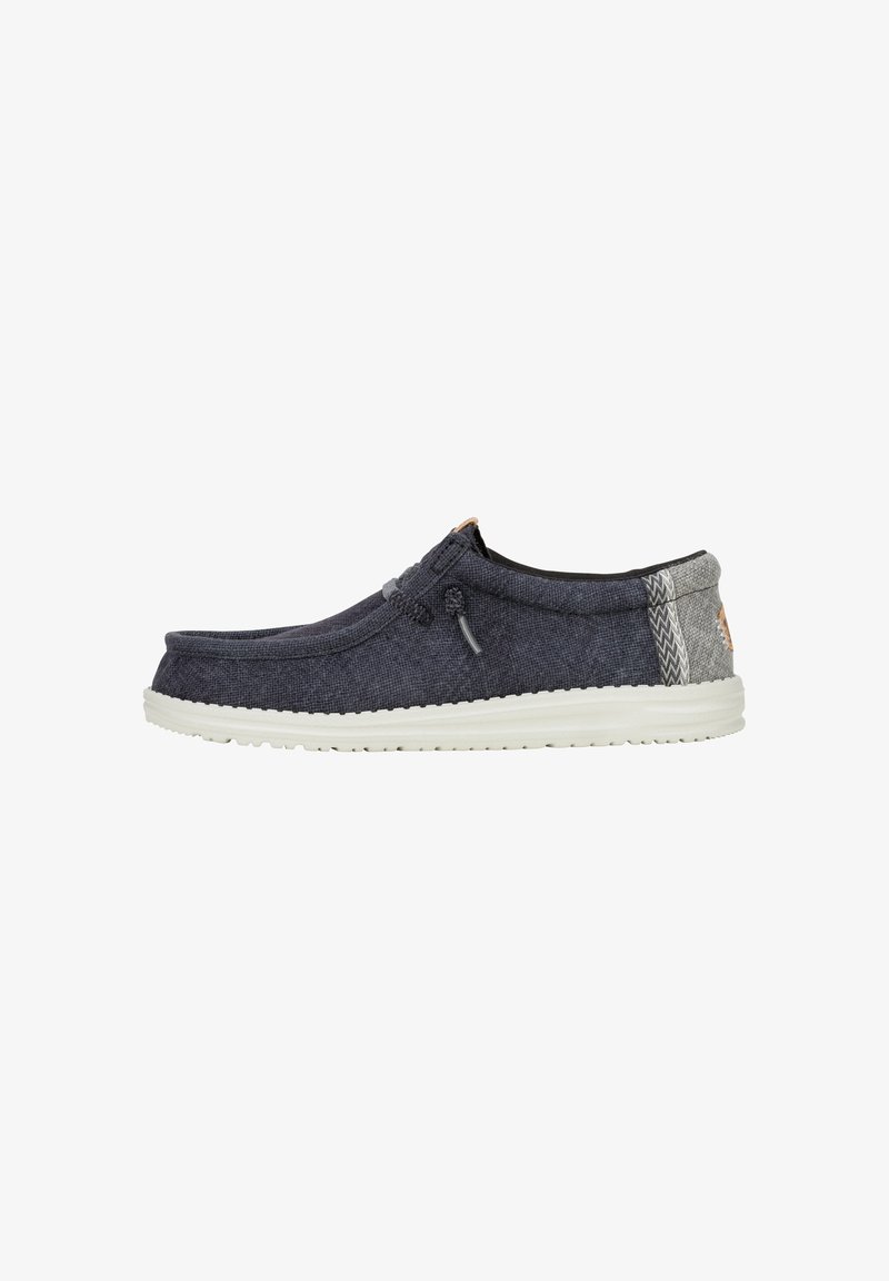 Scarpe slip-on con tomaia in tessuto blu scuro, retro grigio chiaro, suola in gomma bianca e cuciture decorative. Punta rotonda e senza chiusure visibili.