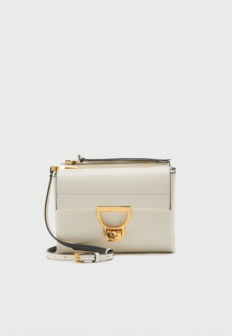 Μικρή κρεμ τσάντα χιαστί από δέρμα με ρυθμιζόμενο λουρί και κούμπωμα με χρυσή πόρπη σε σχήμα D στο μπροστινό καπάκι.