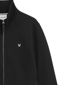 Zwarte zip-up jas van textuurstof, met een zilveren geborduurd logo op de borst en contrasterende gestreepte voering op de kraag.