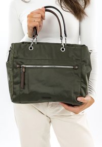 Olivově zelená kabelka z nylonu, se přední kapsou na zip, hnědými koženkovými doplňky a stříbrným kováním, s dvojitými držadly.