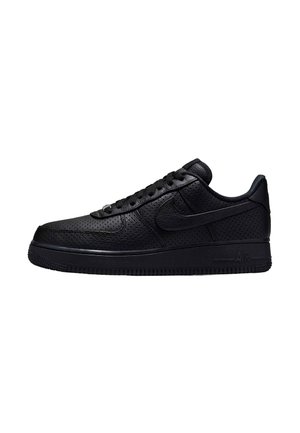 Sneaker Nike Air Force 1 nera a taglio basso con pelle traforata, chiusura frontale con lacci e suola spessa in gomma, vista di profilo su sfondo bianco.