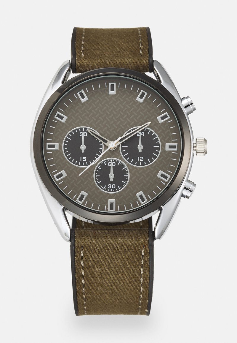 Montre chronographe marron et noire avec un cadran texturé, des accents argentés, des marqueurs d'heure carrés et un bracelet en toile vert olive.
