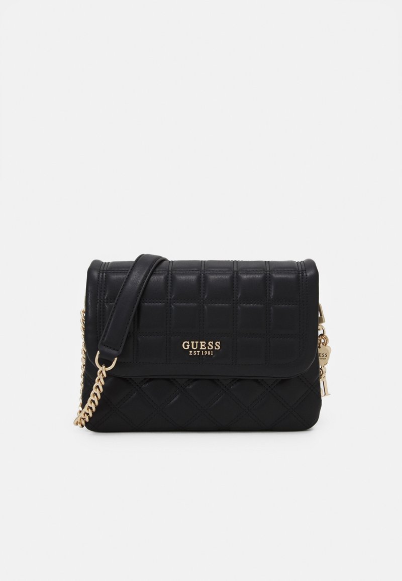 Černá prošívaná kožená taška Guess přes rameno se zlatým řetízkem, klopovým uzávěrem a zlatou destičkou s logem s nápisem "GUESS EST 1981".