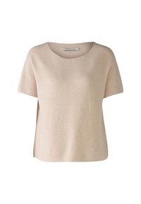 Haut beige à manches courtes avec un col rond, fabriqué en tissu tricot texturé, doté d'une coupe décontractée et de fentes sur les côtés pour plus de confort.