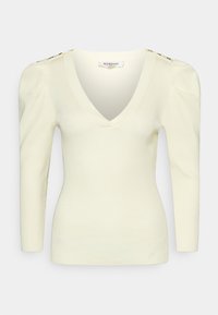 Pull en maille côtelée crème avec un col en V, des épaules bouffantes, des manches longues et des boutons dorés sur les coutures des épaules.