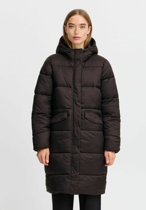 Manteau rembourré de couleur brun foncé, avec une capuche, une fermeture éclair à l'avant et deux poches latérales. Il a une coupe longue et droite avec une texture matelassée.