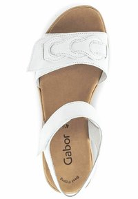 Sandale en cuir blanc avec une large sangle ornée de boucles décoratives, semelle intérieure rembourrée et semelle marron. La marque "Gabor" est visible.