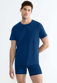 T-shirt in cotone blu navy con maniche corte, scollatura rotonda e texture liscia, abbinato a boxer aderenti blu navy coordinati.