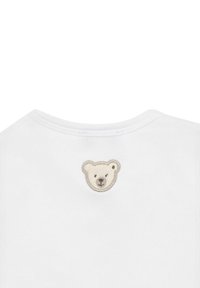 Camiseta de algodón blanca con un rostro de oso bordado en tonos beige y marrón en la parte trasera, con un escote redondeado.