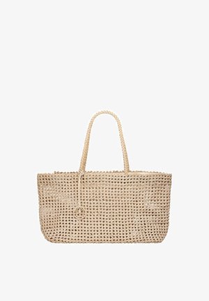 Beżowa pleciona torba na ramię z dwoma uchwytami i małym okrągłym zawieszonym przy górnej krawędzi ozdobnym elementem.