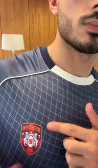 Jūras spēku sporta krekls ar baltām akcentiem, kas rotāts ar dimanta režģa rakstu. Sarkans emblēma ar diviem lauvām, kas uzsvērti izvietota krūšu daļā.