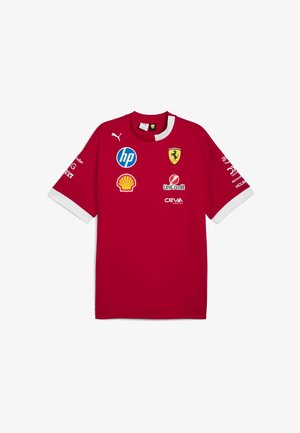 Red Puma short-sleeved shirt featuring a round neckline, white accents, and various logos including Ferrari, HP, and Shell.