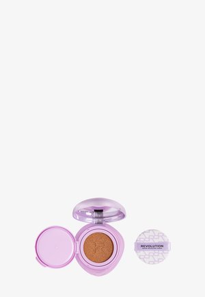 Custodia compatta per fondotinta cushion lavanda viola aperta con spugnetta trucco marrone e puff per cipria separato con etichetta Revolution.