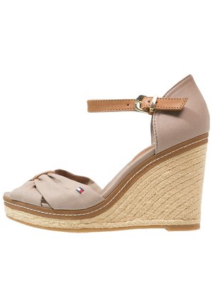 Sandali wedge beige con una fascia per le dita in tessuto annodata, una cinghia alla caviglia color tan e un tacco avvolto in juta con cuciture bianche lungo il bordo.