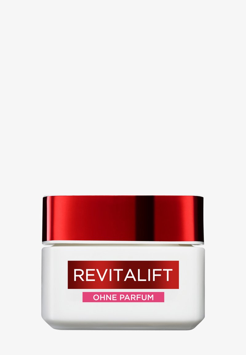 Biały kwadratowy słoik z refleksyjną czerwoną pokrywką. Etykieta z napisem "REVITALIFT" oraz "OHNE PARFUM" w czerwonym i różowym kolorze. Gładka, błyszcząca powierzchnia.