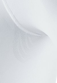 Tissu blanc lisse avec un motif texturé, présentant un mélange de sections lisses et côtelées, mettant en avant l'élasticité et le confort.