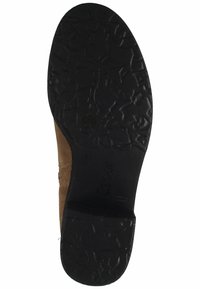 Chaussure en daim marron avec une semelle en caoutchouc noir texturé dotée d'une adhérence à motifs. Logo "Gabor" en relief présent sur la semelle.