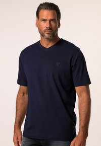 Camiseta de algodón azul marino con escote en V, mangas cortas y un sutil logo "JP" en el pecho. Textura suave, corte relajado.