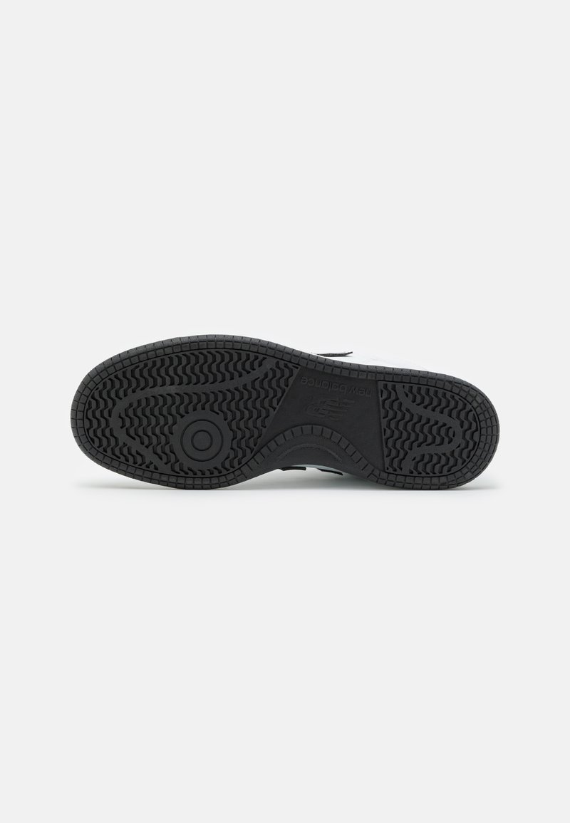 Sole di sneaker nera in gomma con motivo testurizzato per aderenza, caratterizzata da un emblema circolare e linee dettagliate per trazione e stabilità.