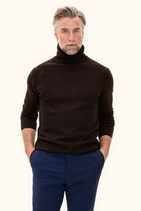 Donkerbruin coltrui gemaakt van zacht materiaal, met een geribde halslijn en manchetten, gecombineerd met marineblauwe broek.